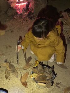 落ち葉をトングでつかむ幼児