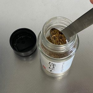 「ほりにし」のキャップを回して開けて、スプーン（小さじ）を入れて固まったほりにしをかき出す様子